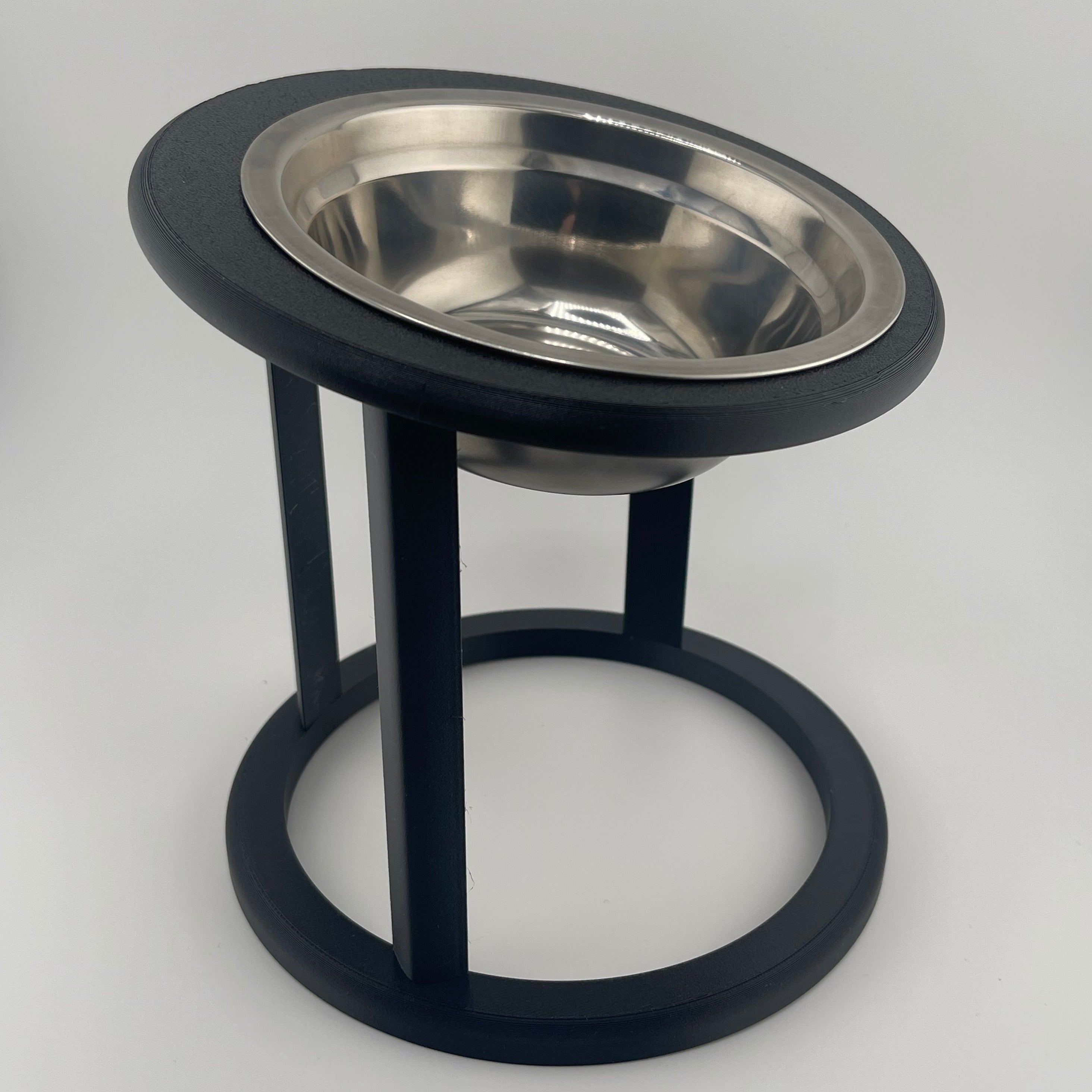 Black raised cat feeder with circular base, side angle view, elevated cat bowl UK
